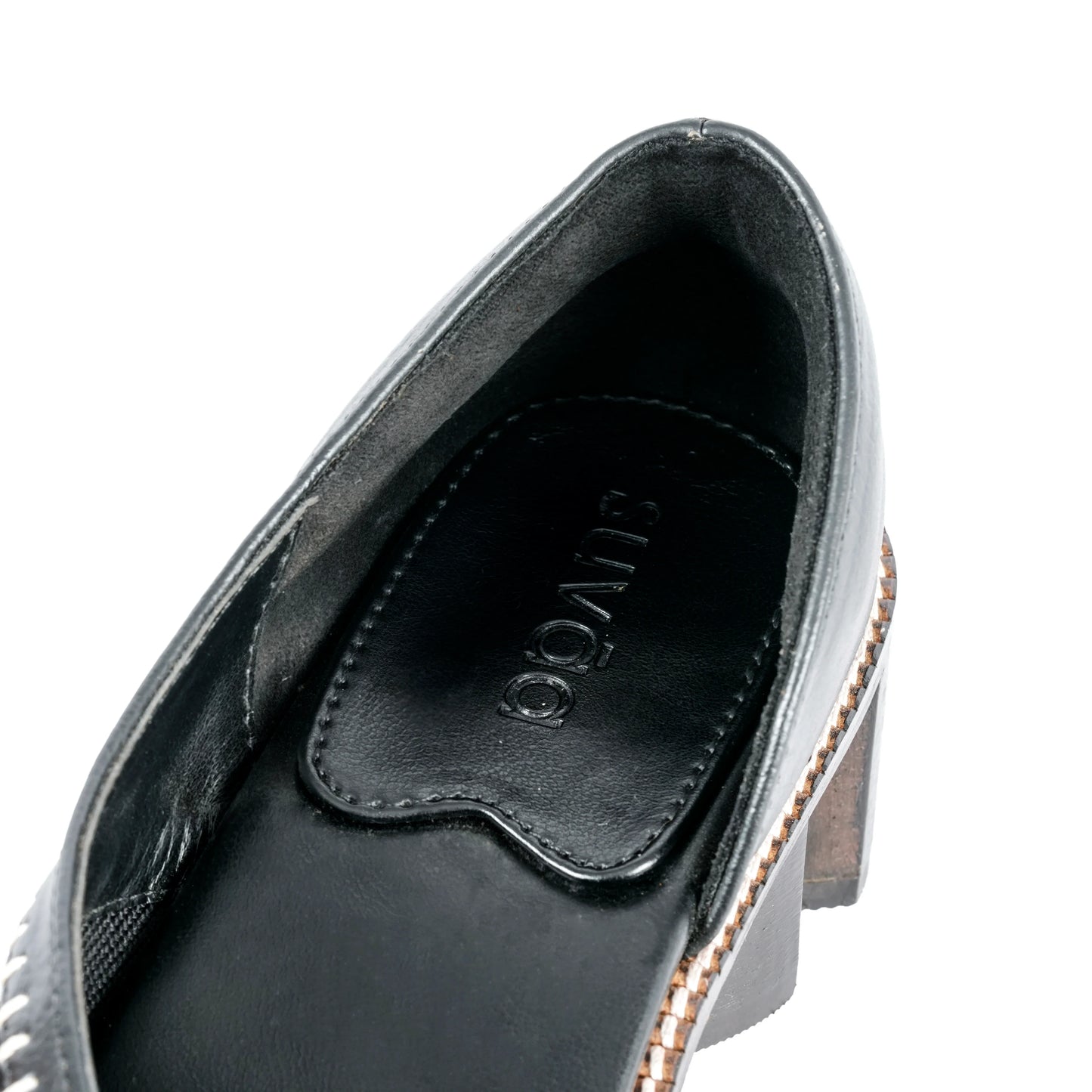 Close-up of a Black shoe with a Suvāa logo on a white background